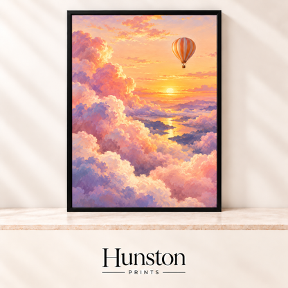 Hot air balloon floating above pink and lavender clouds at a golden sunset