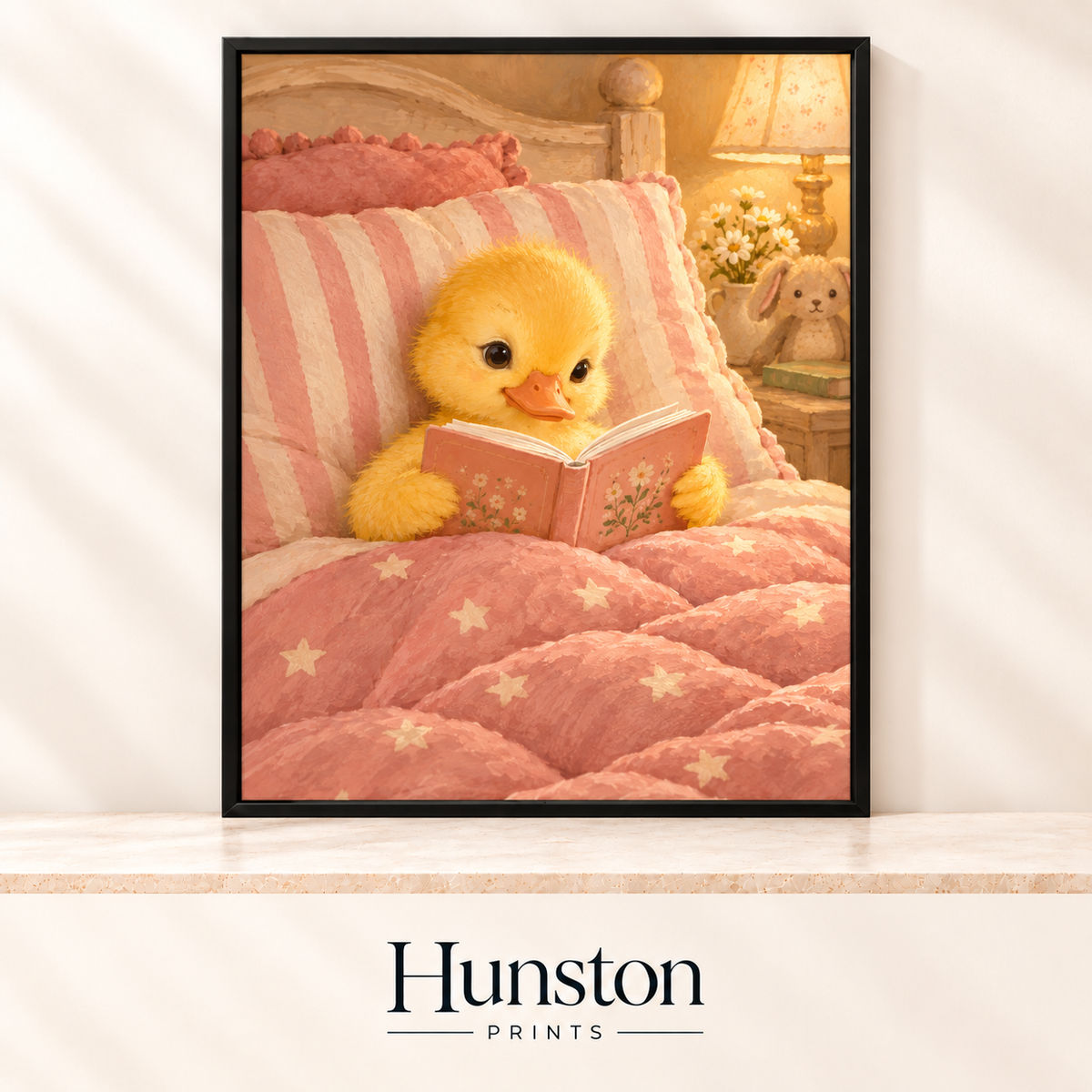 Yellow duckling reading a book in bed under a pink star quilt by lamplight