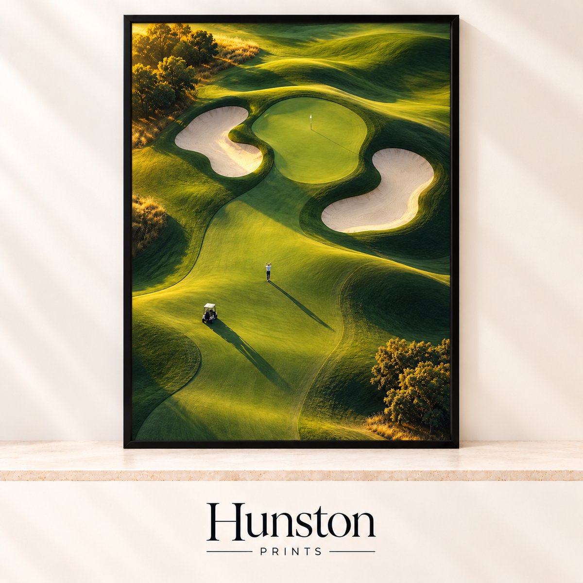 Aerial view of a golf green with sand bunkers, a golfer and buggy at sunrise