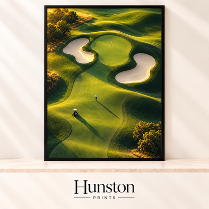 Aerial view of a golf green with sand bunkers, a golfer and buggy at sunrise