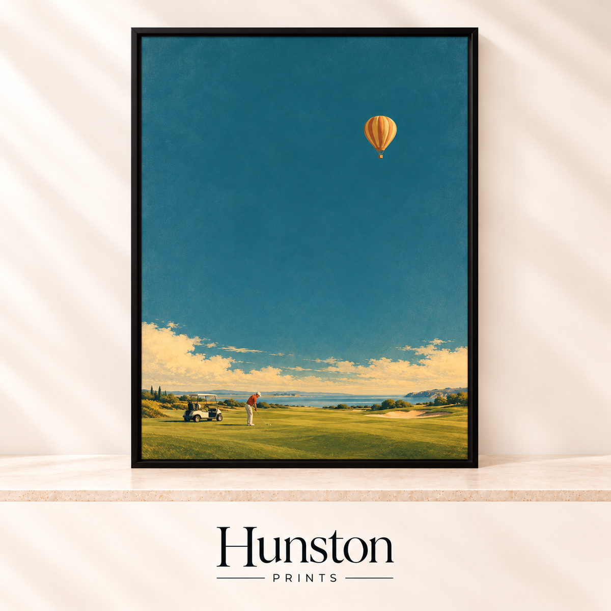 Golfer on a coastal course with a buggy under a teal sky and a striped hot air balloon