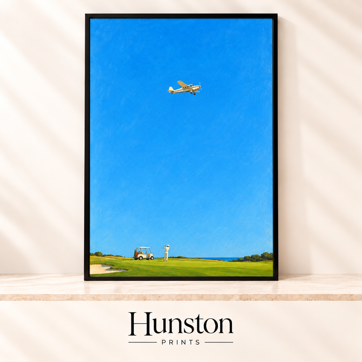 Golfer swinging on a seaside fairway with a buggy as a vintage plane flies across a bright blue sky