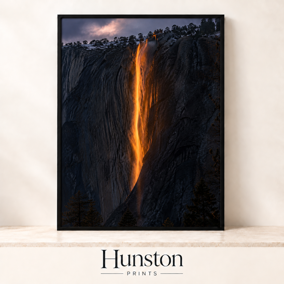 Waterfall glowing orange like fire down a dark granite cliff