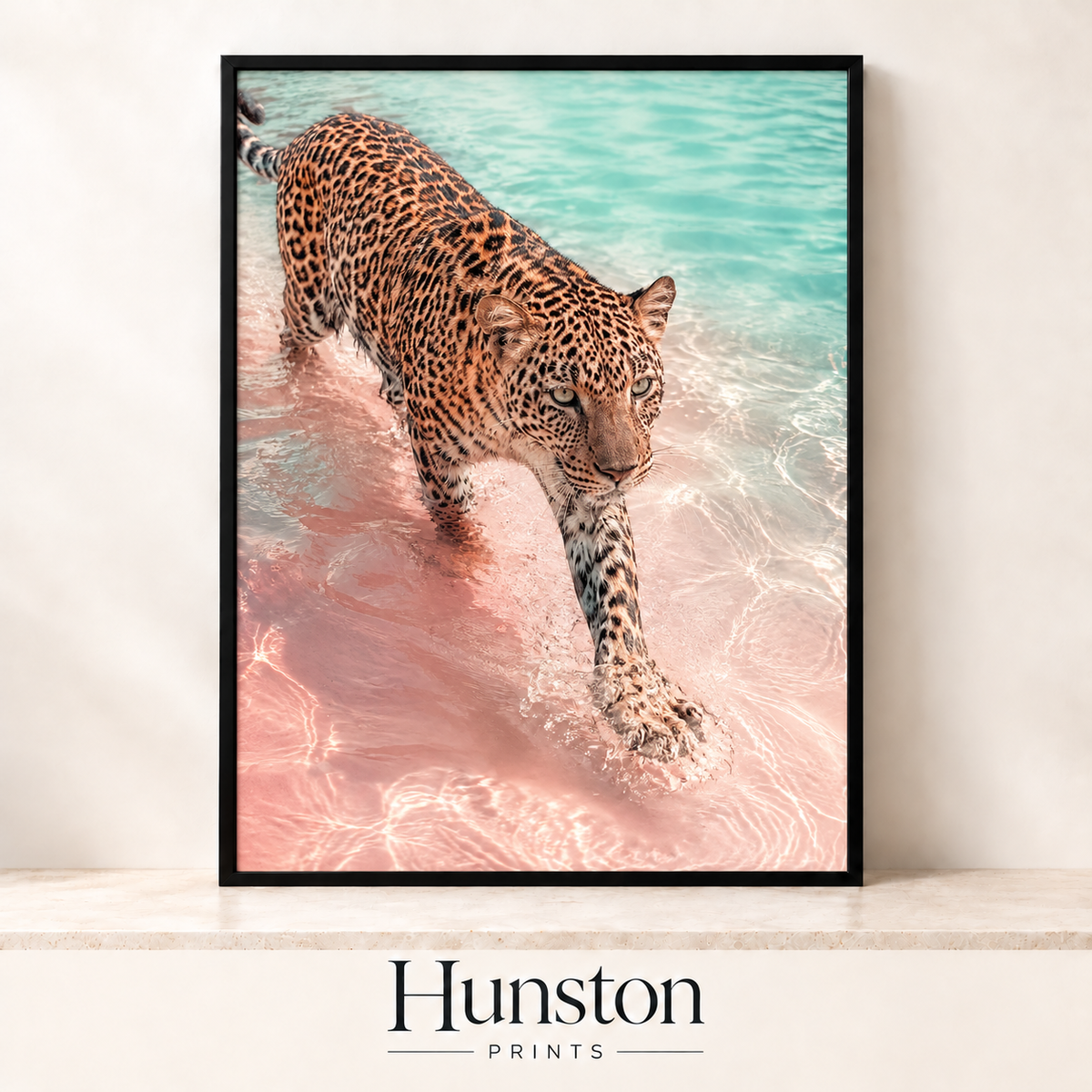 Leopard walking through turquoise water on a pink beach