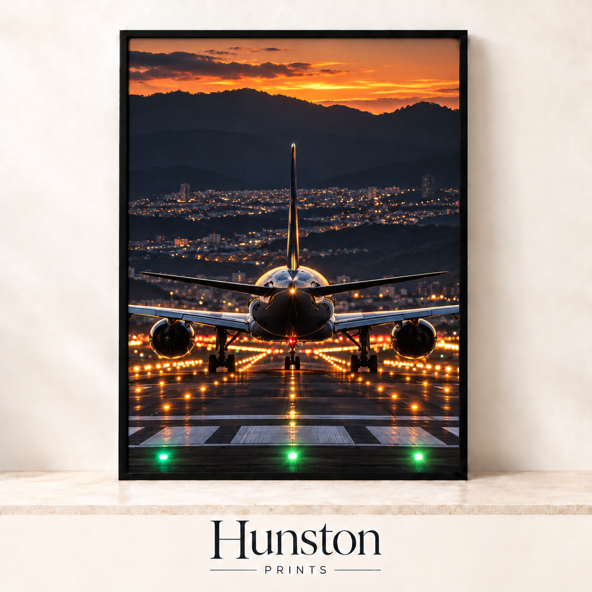 Rear view of a jet on a lit runway with city lights and an orange sunset