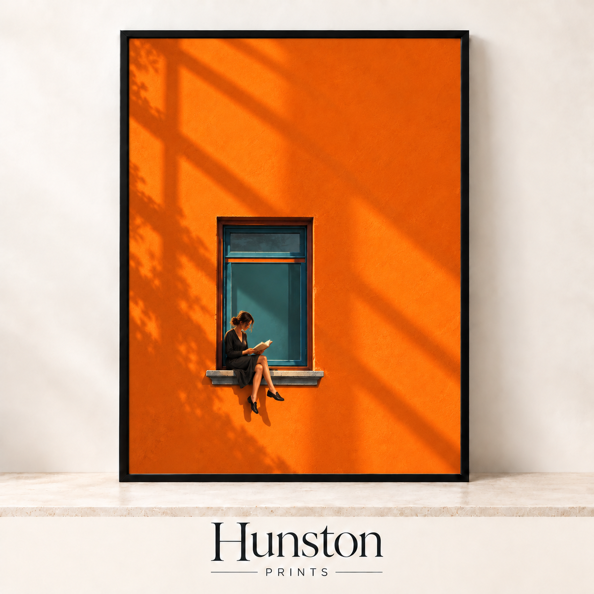 Woman reading a book on a window ledge in a bright orange wall