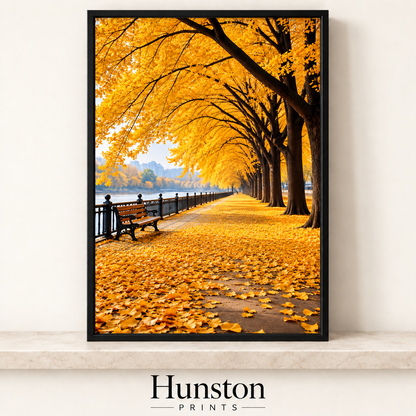 Avenue of golden autumn trees over a leaf-covered riverside path with a bench