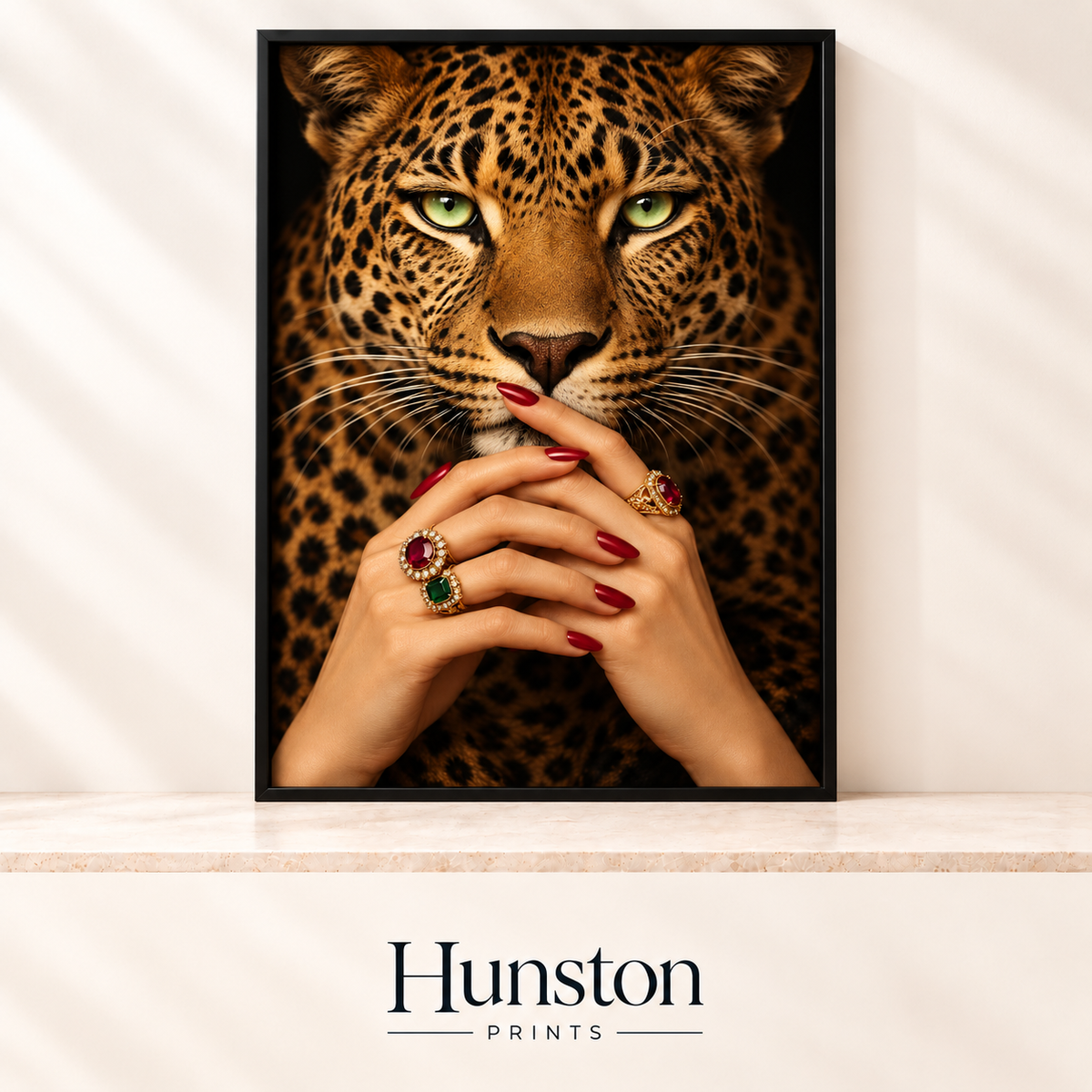 Green-eyed leopard face with hands wearing red nail polish and gold gemstone rings