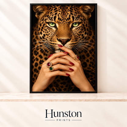 Green-eyed leopard face with hands wearing red nail polish and gold gemstone rings
